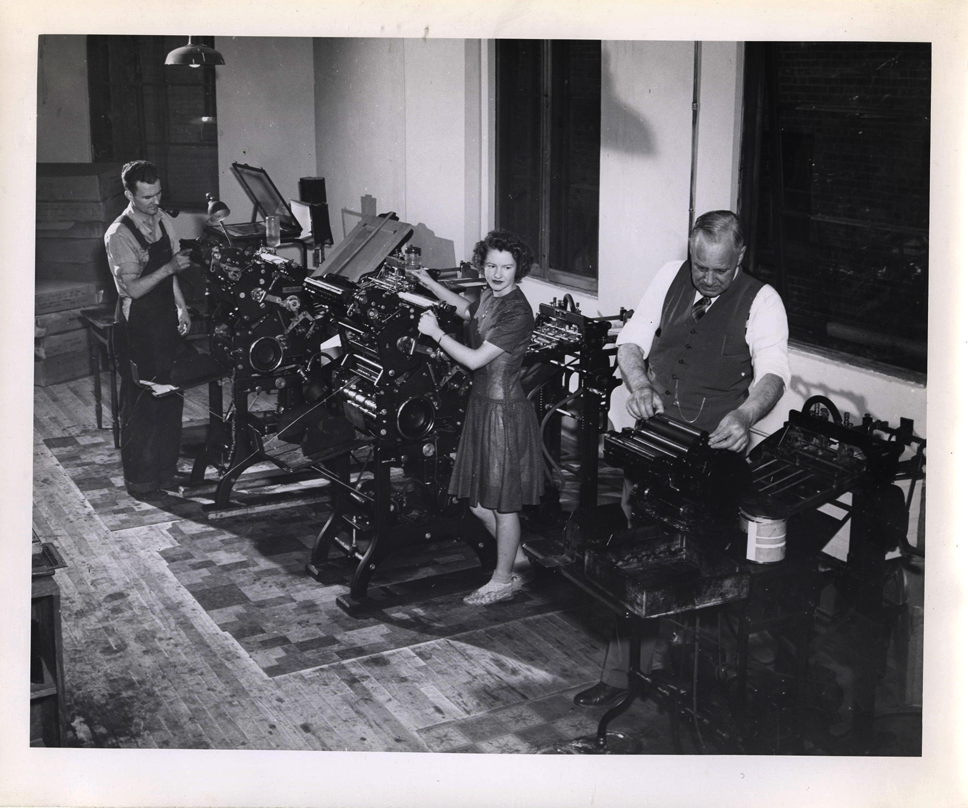 Photograph of Frank B. Robinson adjusting a small printing press.